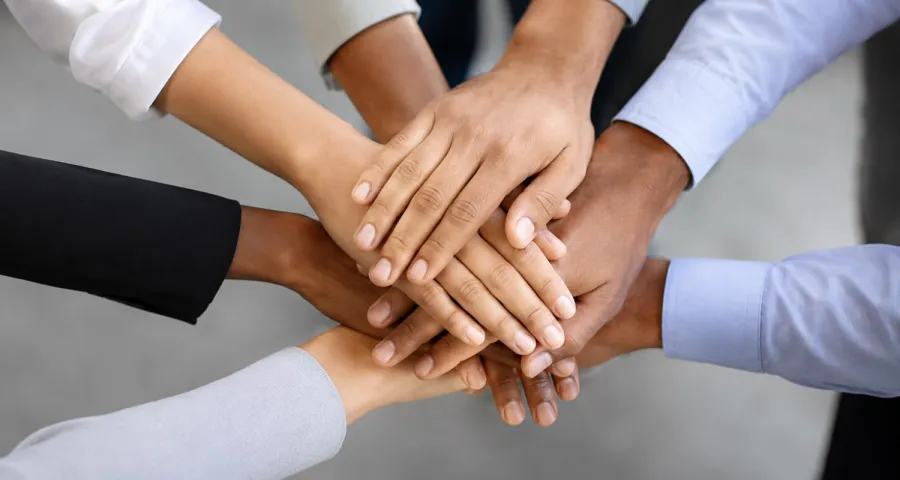 Team members joining hands together